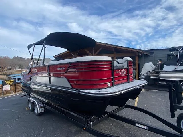 Slide: The Image of 2024 SunCatcher Elite 324 SS pontoon boat on trailer, red and black exterior. - 6