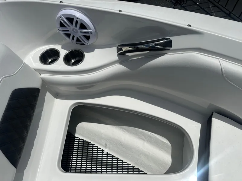 Slide: The Image of 2024 Monterey 224 FS boat interior with speaker, cup holders, and storage compartment. - 15