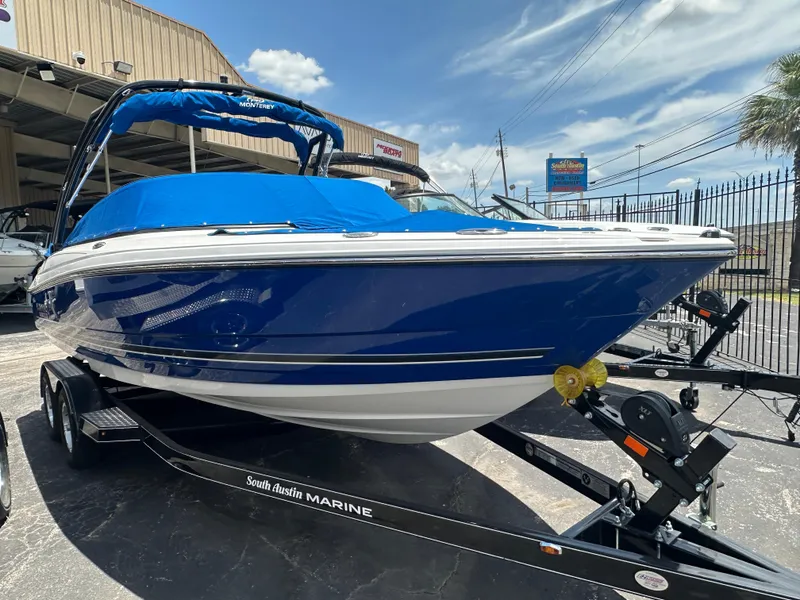 Slide: The Image of 2024 Monterey 224 FS boat with blue cover on trailer at dealership. - 3