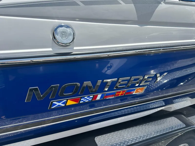Slide: The Image of 2024 Monterey 224 FS boat with nautical flags on blue hull. - 6