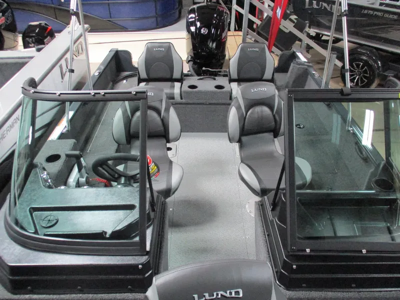 Slide: The Image of 2024 Lund 1650 Rebel XL Sport boat interior with seating and steering console. - 2