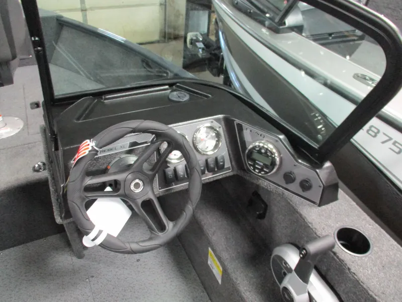 Slide: The Image of 2024 Lund 1650 Rebel XL Sport boat dashboard with steering wheel and control panel. - 3