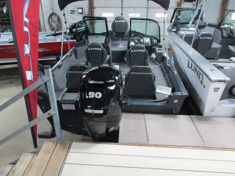 Slide: The Image of 2024 Lund 1650 Rebel XL Sport boat with Mercury 90 engine in showroom. - 8