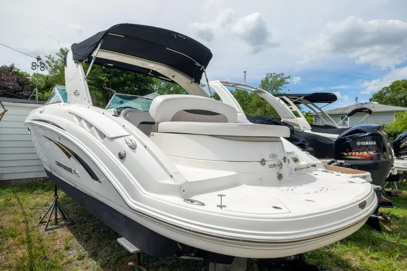 The Image of 2015 Chaparral 287 SSX boat with black canopy, parked outdoors on grass. - 1