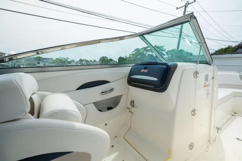 Slide: The Image of 2015 Chaparral 287 SSX boat interior with white seating and sleek dashboard design. - 11