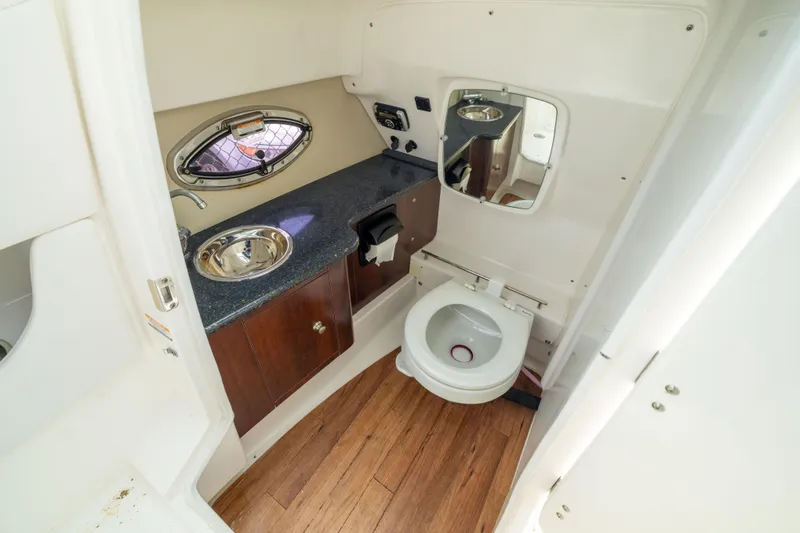 Slide: The Image of 2015 Chaparral 287 SSX boat bathroom with sink, toilet, and mirror. - 19
