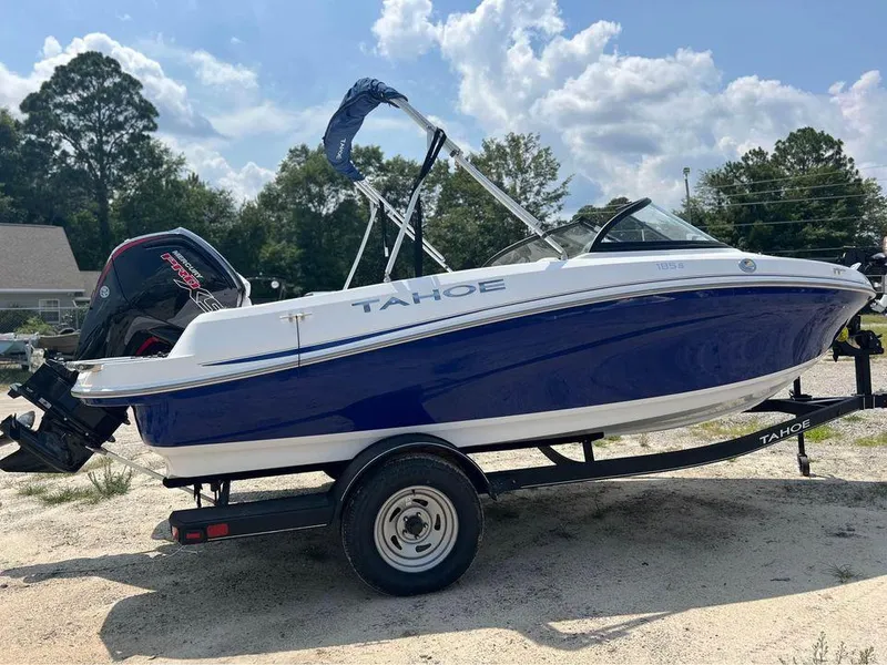 The Image of 2024 Tahoe 185 S boat on trailer, blue and white, parked outdoors. - 0