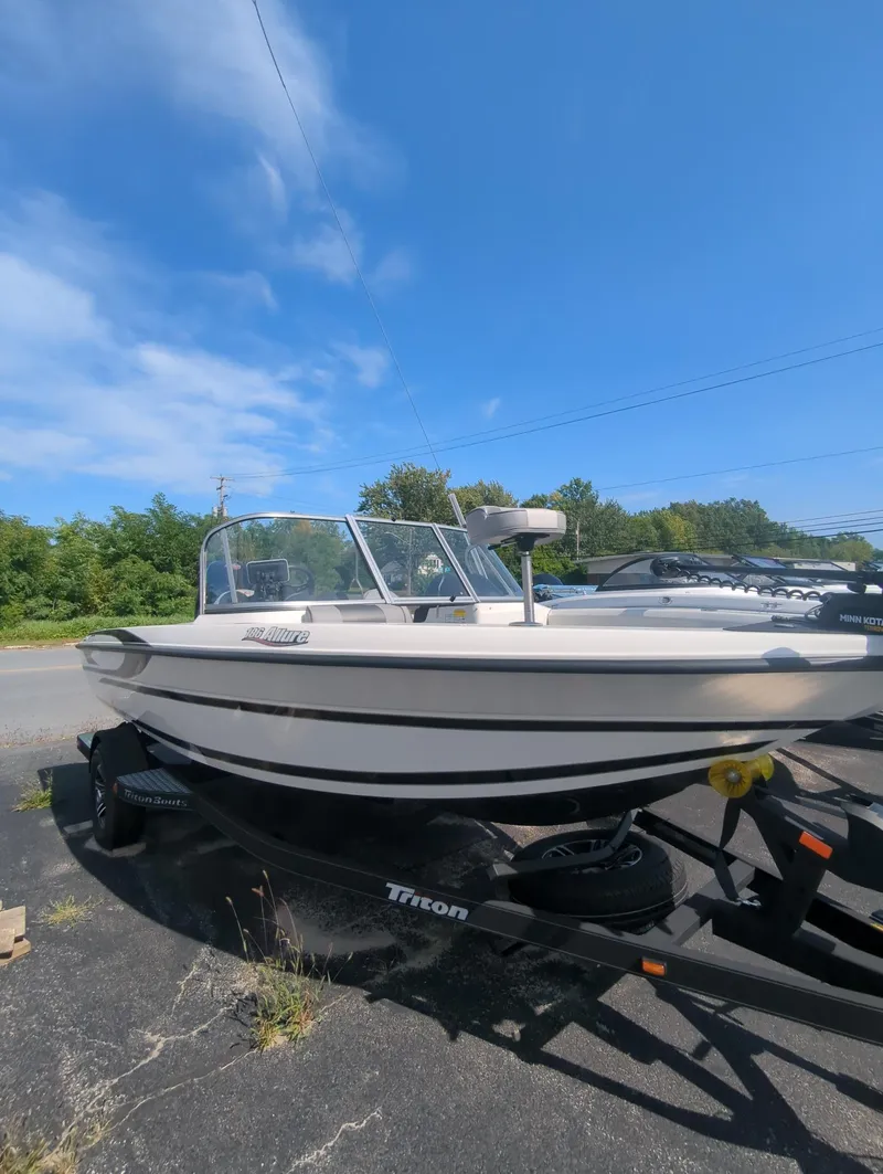The Image of 2024 Triton 186 Allure boat on trailer under clear blue sky. - 0