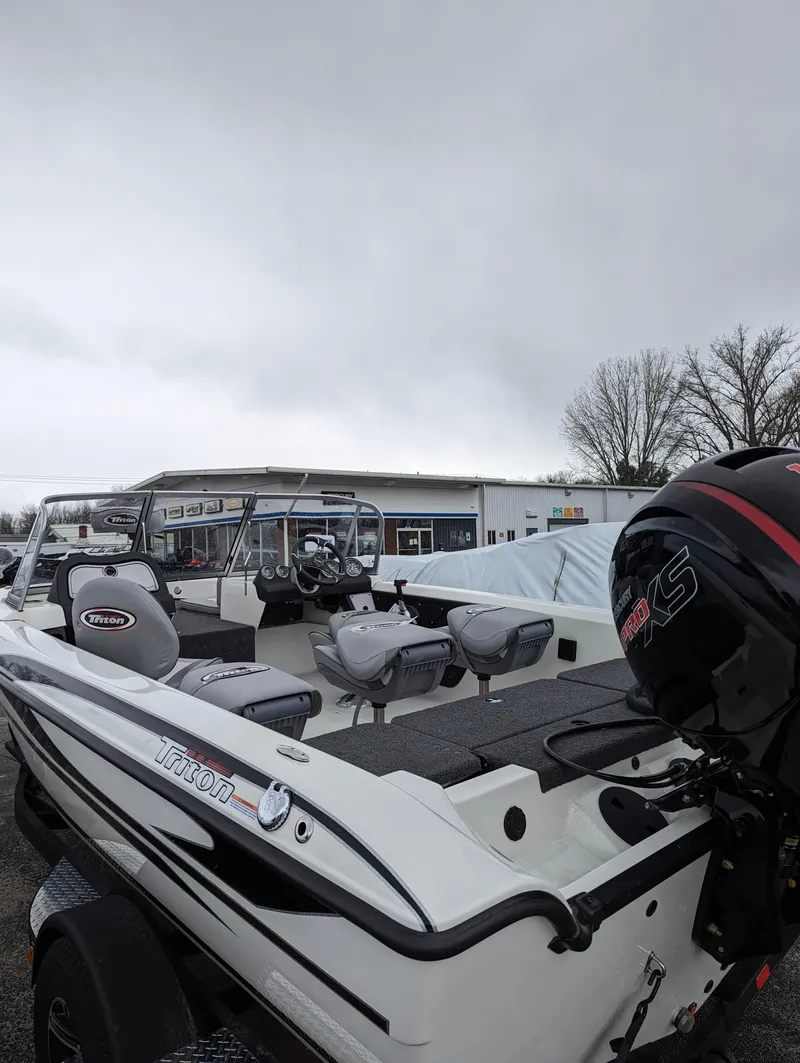 Slide: The Image of 2024 Triton 186 Allure boat with outboard motor in a dealership lot. - 17