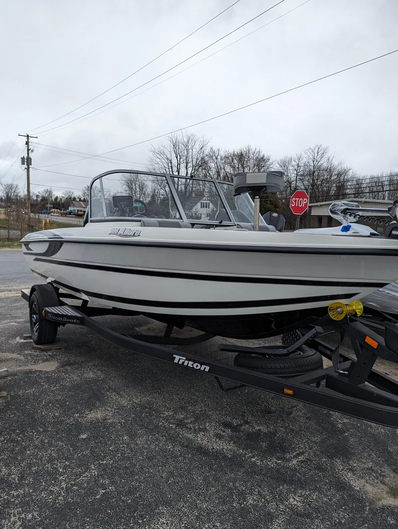 Slide: The Image of 2024 Triton 186 Allure boat on a trailer, parked outdoors. - 8