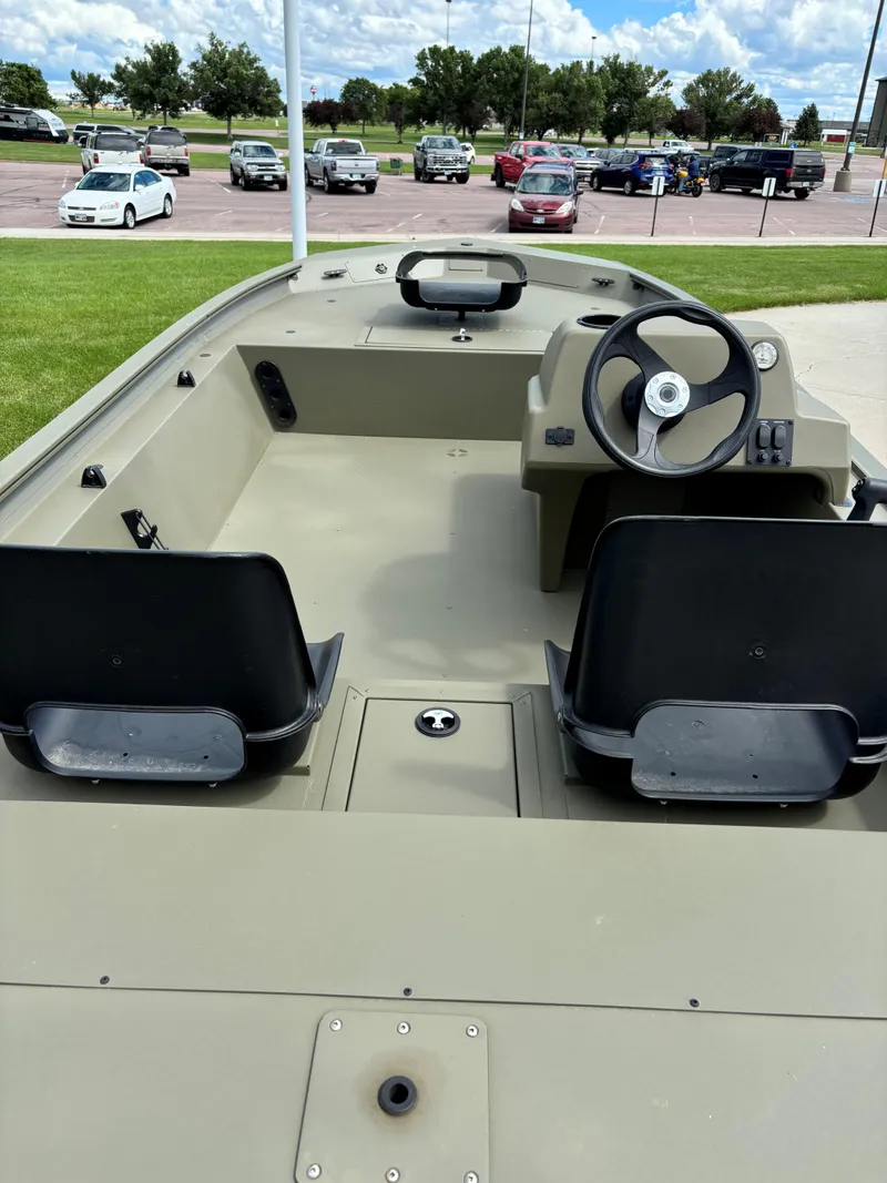 Slide: The Image of 2024 Tracker Grizzly 1754 SC boat interior with steering console and seating. - 4