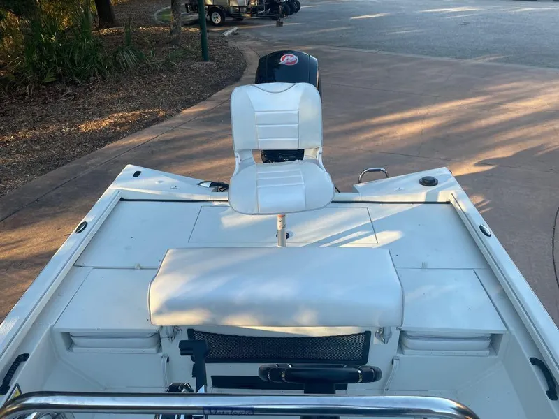 Slide: The Image of 2024 Ranger RB200 boat with white seating and motor, parked on a paved area. - 4