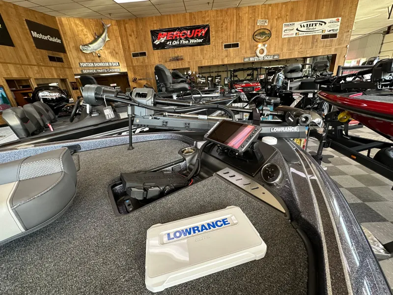 Slide: The Image of 2024 Triton 18 TrX bass boat interior with Lowrance electronics in showroom. - 2
