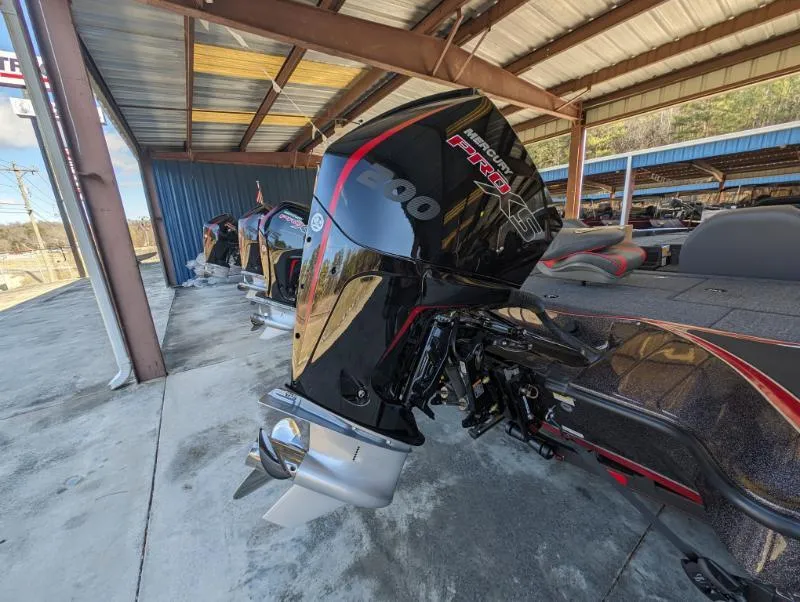 Slide: The Image of 2024 Triton 18 TrX boat with powerful outboard motor in a covered storage area. - 1