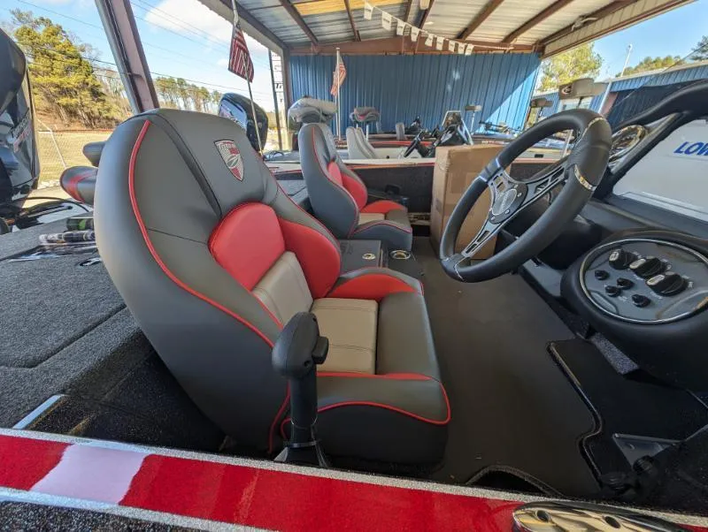 Slide: The Image of 2024 Triton 18 TrX boat interior with red and gray seats, steering wheel, and controls. - 6
