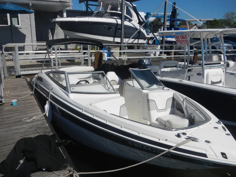The Image of 2009 Larson 238 LXi boat docked at marina, white and black exterior. - 0