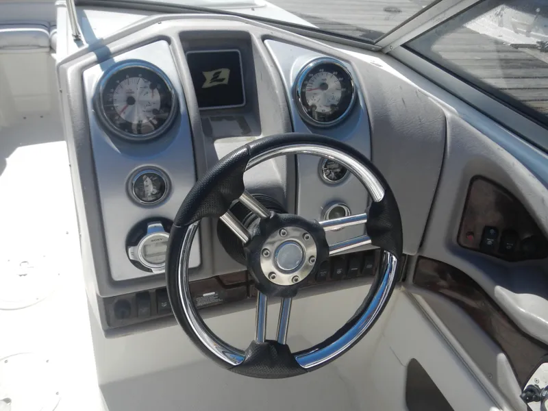 Slide: The Image of 2009 Larson 238 LXi boat dashboard with steering wheel and gauges. - 12