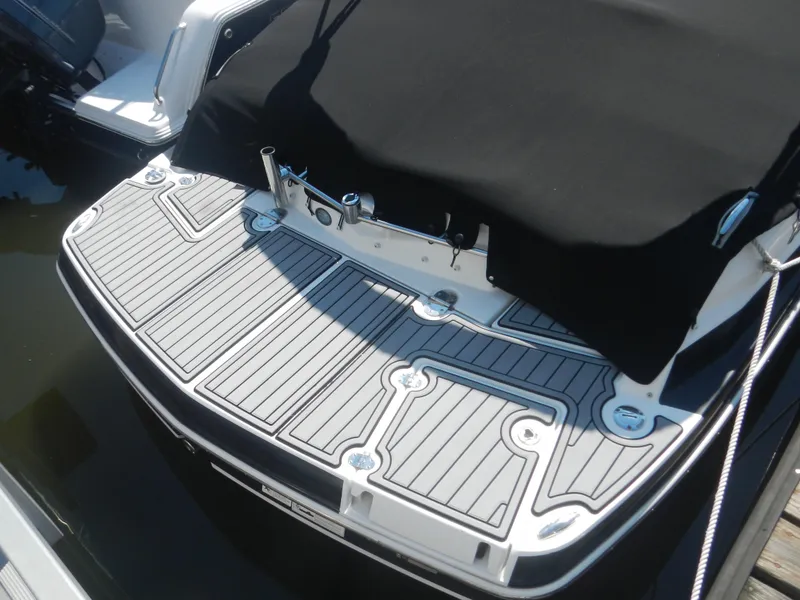 Slide: The Image of 2009 Larson 238 LXi boat with covered deck at the dock. - 2