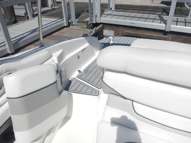 Slide: The Image of 2009 Larson 238 LXi boat interior with white seating and dock in background. - 9