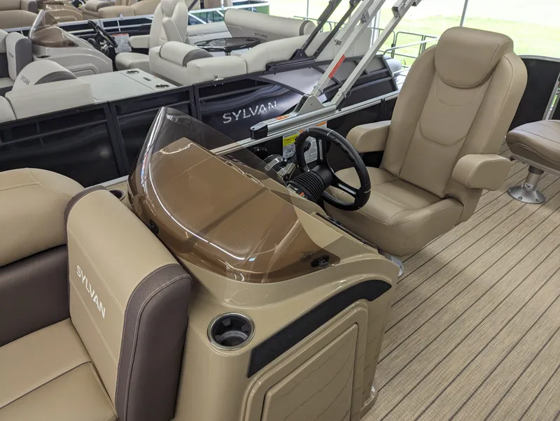 Slide: The Image of 2024 Sylvan Mirage Fish 8522 Party Fish boat interior with beige seating and steering console. - 5