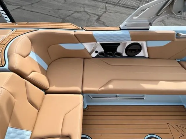 Slide: The Image of 2024 MasterCraft XT23 boat, rear view, blue and white with teak deck, parked outdoors. - 15