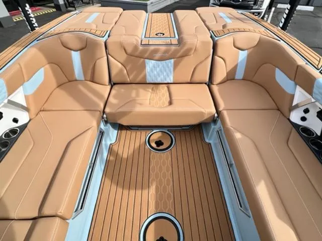 Slide: The Image of 2024 MasterCraft XT23 boat on trailer, blue and white design, outdoor display. - 16