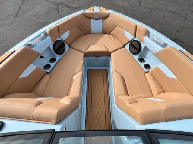 Slide: The Image of 2024 MasterCraft XT23 boat interior with tan seats and blue accents. - 18