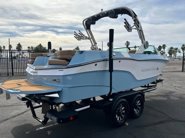 Slide: The Image of 2024 MasterCraft XT23 boat with tan seating and blue accents in a pool. - 6