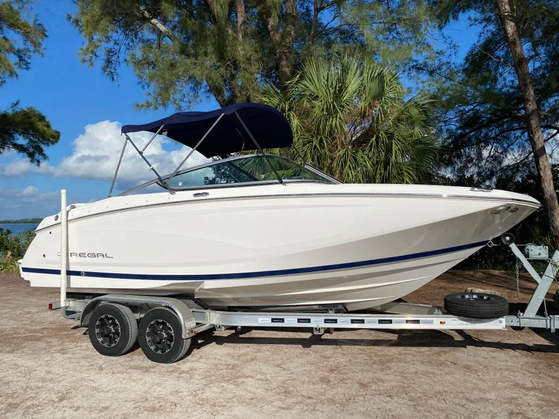 Slide: The Image of 2017 Regal 22 FasDeck boat on a trailer with a blue canopy. - 11