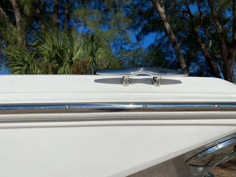 Slide: The Image of 2017 Regal 22 FasDeck boat with chrome rail and cleat against a forest backdrop. - 14