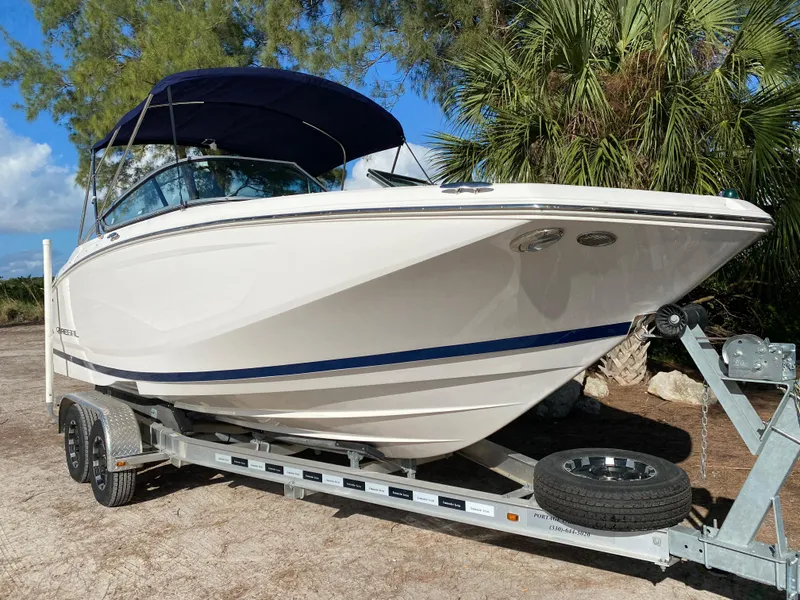 Slide: The Image of 2017 Regal 22 FasDeck boat on trailer with blue canopy. - 2