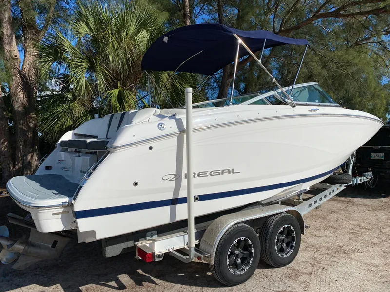 Slide: The Image of 2017 Regal 22 FasDeck boat on a trailer with a blue canopy. - 3