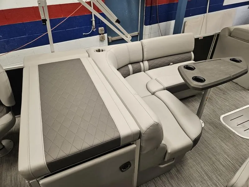 Slide: The Image of 2024 Bennington 22 LSAPG pontoon boat interior with plush seating and table. - 12
