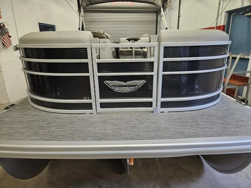 Slide: The Image of 2024 Bennington 22 LSAPG pontoon boat front view in a showroom. - 2