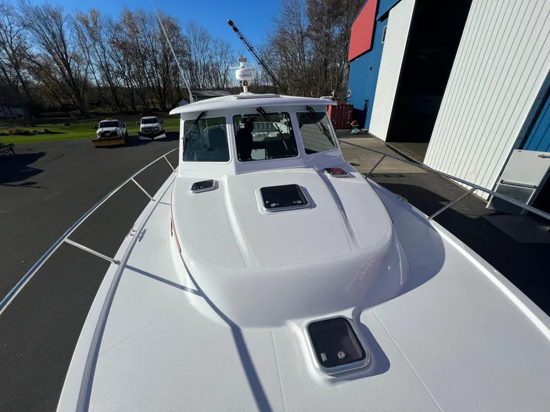 Slide: The Image of 2017 Back Cove Downeast 37 boat docked near a warehouse. - 11