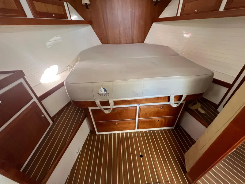 Slide: The Image of 2017 Back Cove Downeast 37 cabin interior with bed and wooden storage drawers. - 49