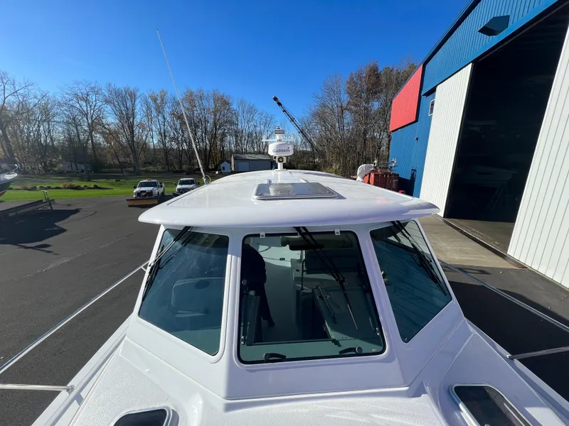 Slide: The Image of 2017 Back Cove Downeast 37 boat docked near a blue and red building. - 12