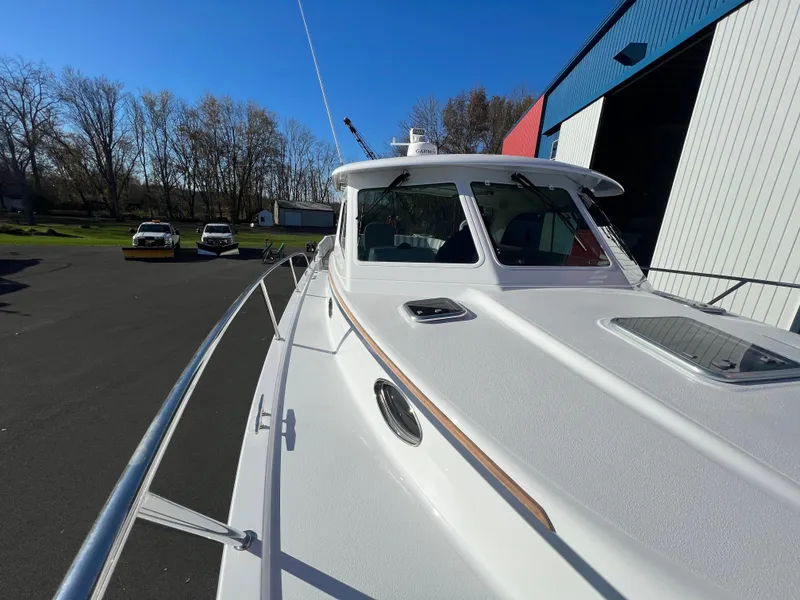 Slide: The Image of 2017 Back Cove Downeast 37 boat docked near a warehouse. - 14