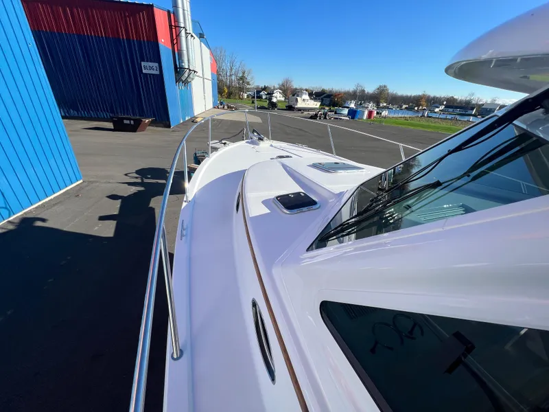 Slide: The Image of 2017 Back Cove Downeast 37 yacht docked, showcasing sleek white deck and railings. - 19