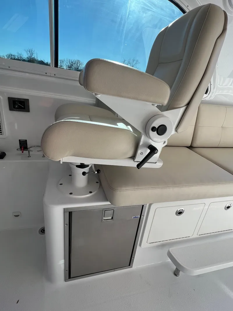 Slide: The Image of Captain's chair on 2017 Back Cove Downeast 37 boat, beige upholstery, white base. - 43