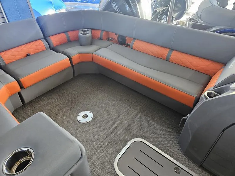Slide: The Image of 2024 Bennington 24LFBC boat interior with gray and orange seating. - 2