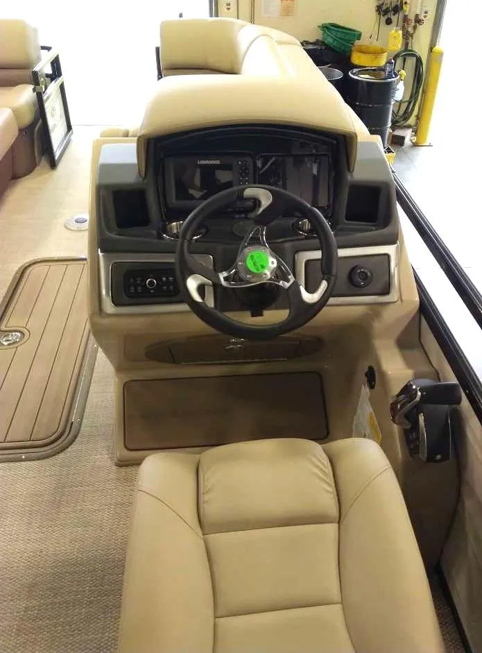 Slide: The Image of 2024 Regency 230 DL3 boat helm with beige seating and modern controls. - 3