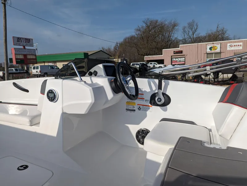 Slide: The Image of 2024 Tahoe T16 boat interior with steering wheel and dashboard, parked at a dealership. - 12