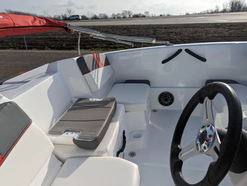 Slide: The Image of 2024 Tahoe T16 boat interior with white and red seating, steering wheel, and storage compartments. - 17