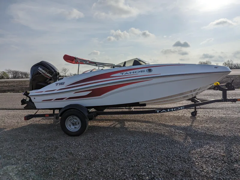 Slide: The Image of 2024 Tahoe T16 boat on a trailer, side view with red and white design. - 8