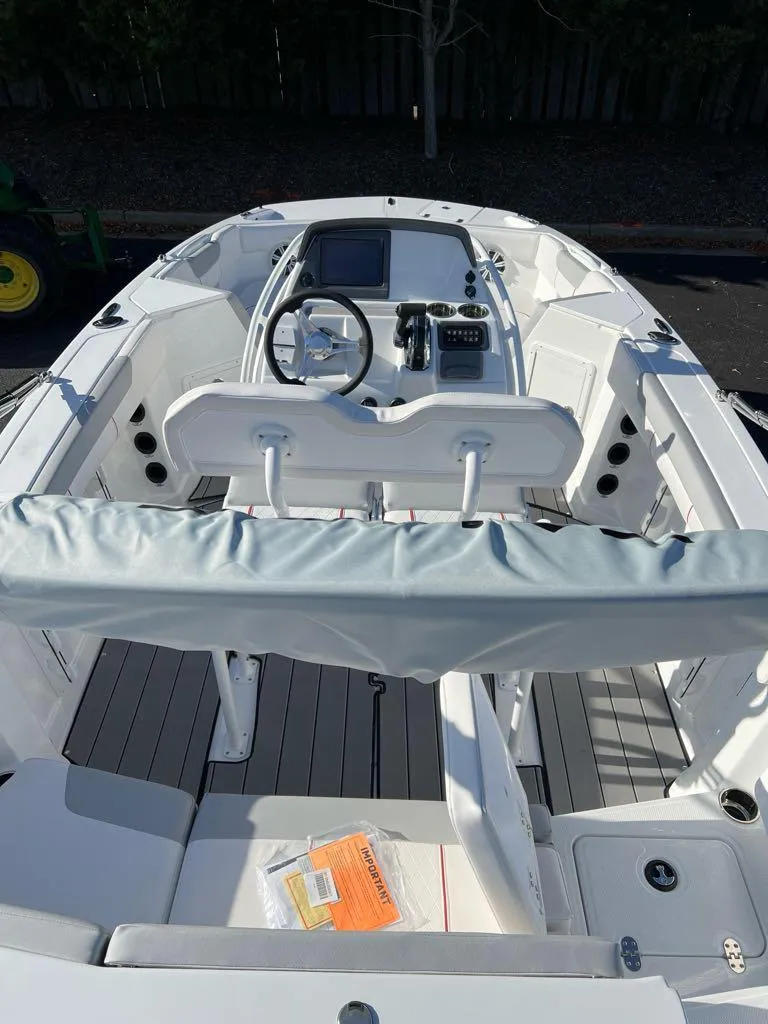 Slide: The Image of 2024 Tahoe 2150 CC boat interior with steering console and seating. - 2