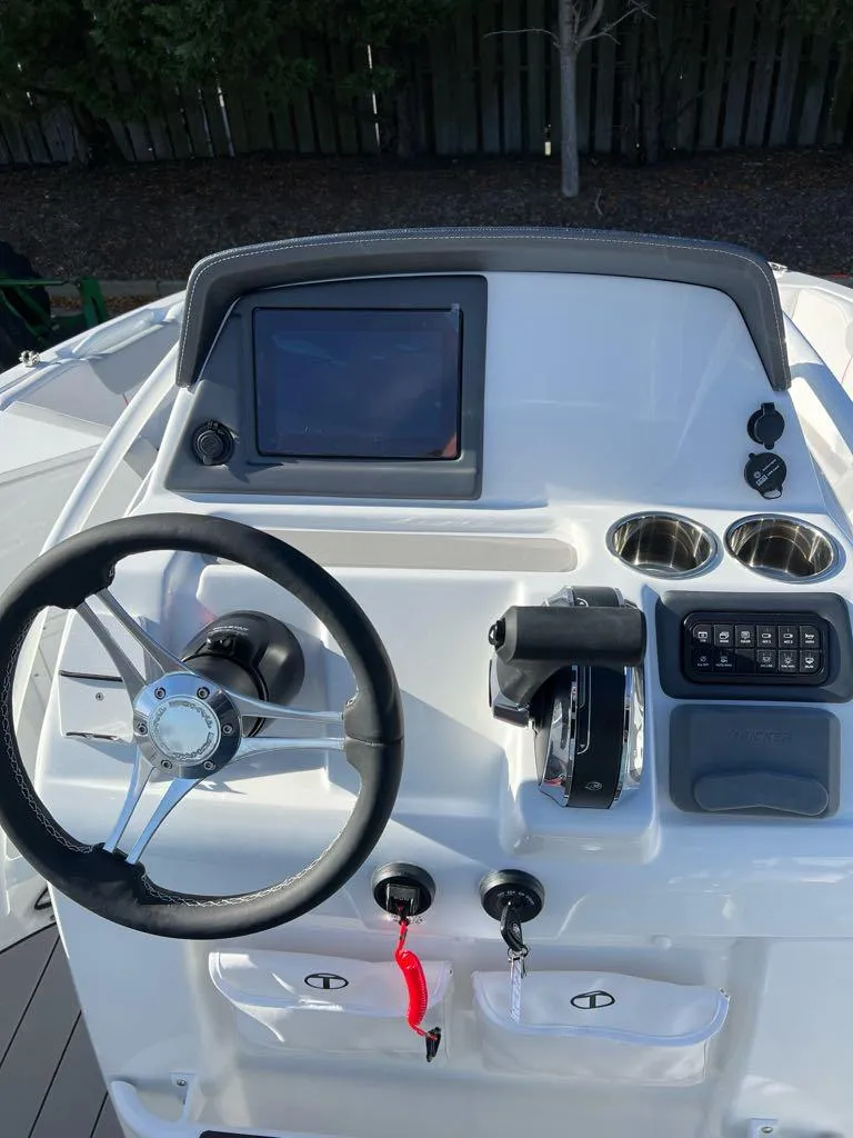 Slide: The Image of 2024 Tahoe 2150 CC boat dashboard with steering wheel and control panel. - 3