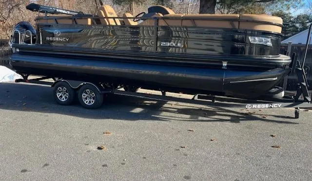 The Image of 2024 Regency 230 LE3 pontoon boat on a trailer. - 0