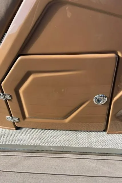 Slide: The Image of 2024 Regency 230 LE3 boat storage compartment with metallic brown finish. - 11
