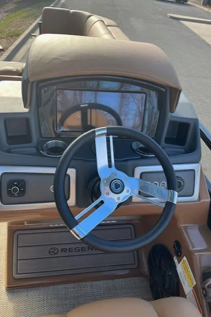 Slide: The Image of 2024 Regency 230 LE3 boat dashboard and steering wheel. - 16